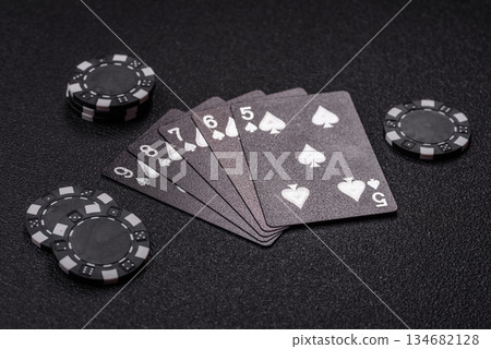 Playing card game poker in casino with chips, bets and risk. Cards and chips on black felt Playing card game poker in casino with chips, bets and risk. Cards and chips on black felt 134682128