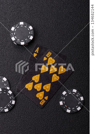 Playing blackjack or baccarat card game in casino with chips. Cards and chips on black felt Playing blackjack or baccarat card game in casino with chips. Cards and chips on black felt 134682144