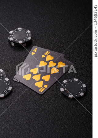 Playing blackjack or baccarat card game in casino with chips. Cards and chips on black felt Playing blackjack or baccarat card game in casino with chips. Cards and chips on black felt 134682145