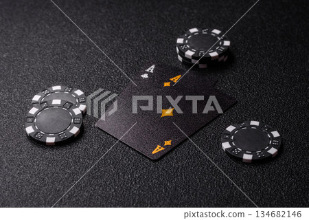 Playing blackjack or baccarat card game in casino with chips. Cards and chips on black felt Playing blackjack or baccarat card game in casino with chips. Cards and chips on black felt 134682146