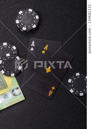 Playing blackjack or baccarat card game in casino with chips. Cards and chips on black felt 134682151