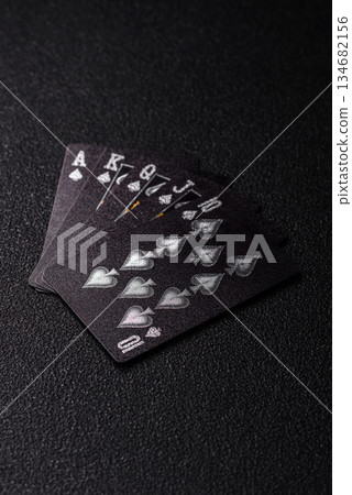 Playing card game poker in casino with chips, bets and risk. Cards and chips on black felt 134682156