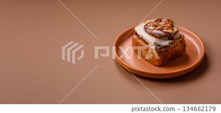 Cinnabon, a sweet cinnamon pastry, a high calorie bun or roll. Cinnabon with cinnamon 134682179