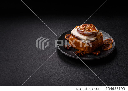 Cinnabon, a sweet cinnamon pastry, a high calorie bun or roll. Cinnabon with cinnamon 134682193