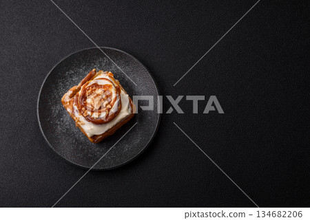 Cinnabon, a sweet cinnamon pastry, a high calorie bun or roll. Cinnabon with cinnamon 134682206