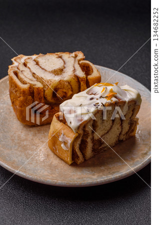 Cinnabon, a sweet cinnamon pastry, a high calorie bun or roll. Cinnabon with cinnamon Cinnabon, a sweet cinnamon pastry, a high calorie bun or roll. Cinnabon with cinnamon 134682252