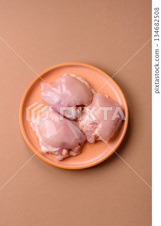 Chicken thigh fillet, skinless and boneless meat for grilling or barbecue. Chicken thigh fillet Chicken thigh fillet, skinless and boneless meat for grilling or barbecue. Chicken thigh fillet 134682508