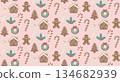 A cute vector seamless Christmas pattern with gingerbread houses, cookies, and candy canes on a pastel pink background.  134682939
