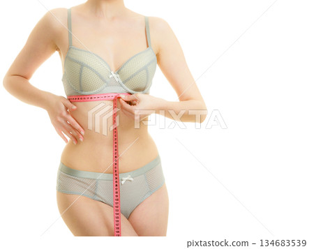 Woman in bra lingerie measuring her chest breasts. Woman in bra lingerie measuring her chest breasts. 134683539