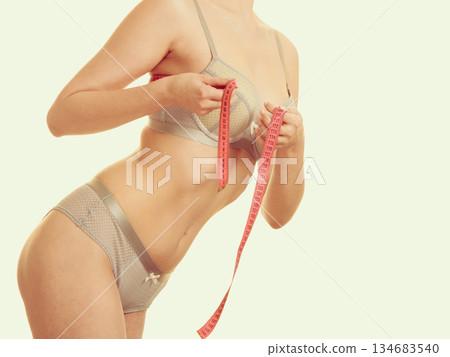 Woman measuring her breasts. 134683540