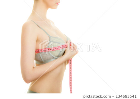 Woman in bra lingerie measuring her chest breasts. 134683541