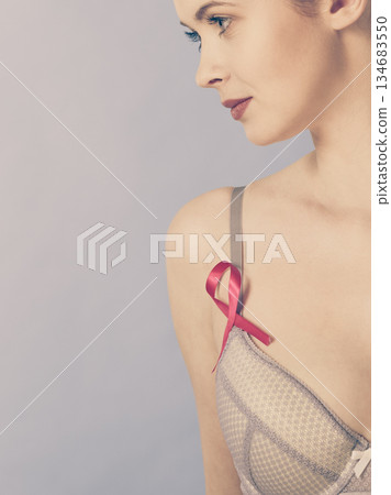 woman in bra with breast cancer awareness ribbon 134683550