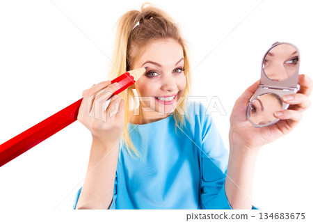 Woman painting eyebrows using regular pencil 134683675
