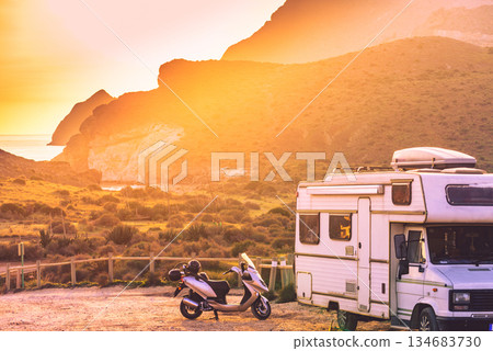 Scooter at camper camping on mountain nature at sunset. Scooter at camper camping on mountain nature at sunset. 134683730