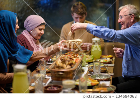 Muslim family enjoys iftar together at a restaurant during Ramadan with festive decorations and shared food 134684068