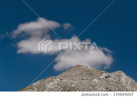 Rocky Mountain Peak with Cloud in Blue Sky Rocky Mountain Peak with Cloud in Blue Sky 134684097