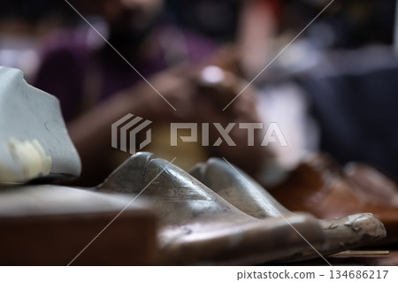 Close up of a metallic shoe in a row at a crowded indoor event Close up of a metallic shoe in a row at a crowded indoor event 134686217