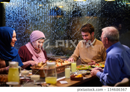 Muslim family enjoys iftar meal together in restaurant during Ramadan with traditional decorations 134686367