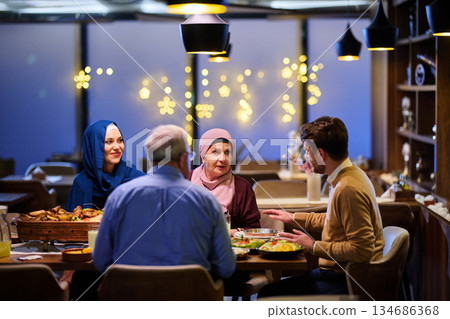Muslim family enjoying iftar together in a restaurant decorated for Ramadan 134686368