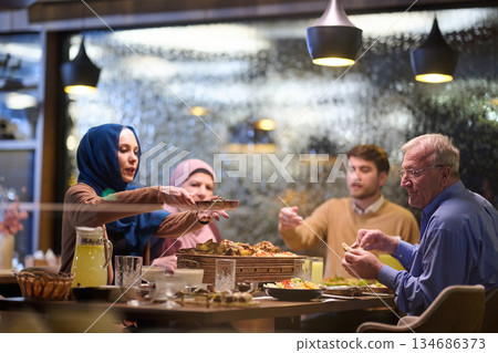 Muslim family breaks fast during Ramadan in a cozy restaurant setting with festive decorations Muslim family breaks fast during Ramadan in a cozy restaurant setting with festive decorations 134686373