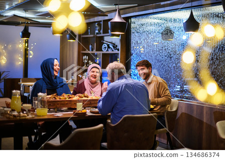 Muslim family gathering for iftar in a restaurant with Ramadan decorations and warm lighting Muslim family gathering for iftar in a restaurant with Ramadan decorations and warm lighting 134686374