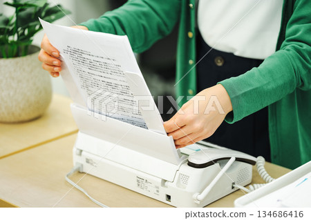 A woman's hands sending a fax A woman's hands sending a fax 134686416