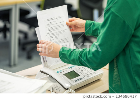 一隻女人的手正在傳送傳真 134686417