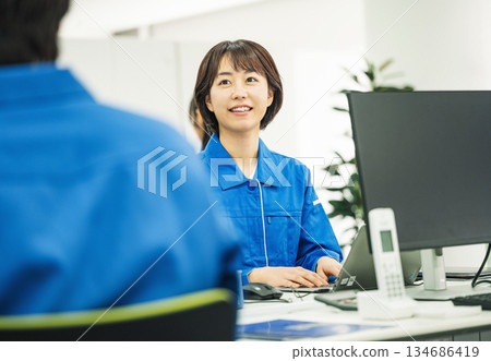 一位身穿職業裝的年輕女子在辦公室裡做案頭工作。 134686419