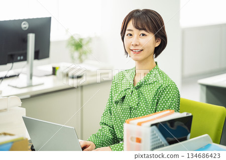 在辦公桌前工作的年輕女僱員 在辦公桌前工作的年輕女僱員 134686423