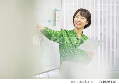 一位年輕的職業婦女在會議上做演講。 134686430