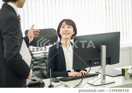 A career woman in a managerial position talking to her subordinates A career woman in a managerial position talking to her subordinates 134686438