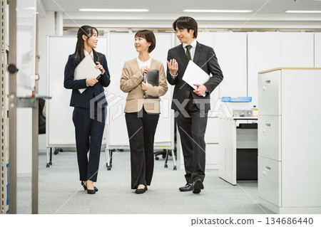 A young business person walking and talking with a colleague A young business person walking and talking with a colleague 134686440
