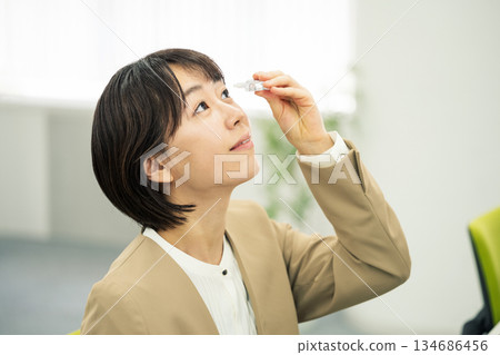 年輕女子在辦公室滴眼藥水 年輕女子在辦公室滴眼藥水 134686456