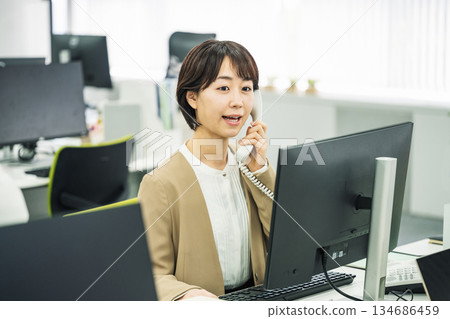 辦公室接電話的年輕女子 辦公室接電話的年輕女子 134686459
