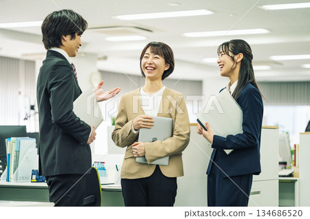 辦公室裡,男女員工正在和同事聊天。 辦公室裡,男女員工正在和同事聊天。 134686520