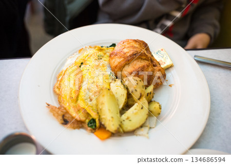 Breakfast Plate with Omelette, Croissant, and Roasted Potatoes Breakfast Plate with Omelette, Croissant, and Roasted Potatoes 134686594
