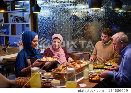 Muslim family enjoying iftar meal in a restaurant with Ramadan decorations during evening hours 134686639