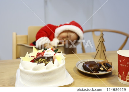溫馨的聖誕蛋糕、家庭聚會和熟睡的日本寶寶。 溫馨的聖誕蛋糕、家庭聚會和熟睡的日本寶寶。 134686659