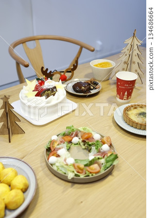 A dining table lined with food and cake from a Christmas party at home. A dining table lined with food and cake from a Christmas party at home. 134686664