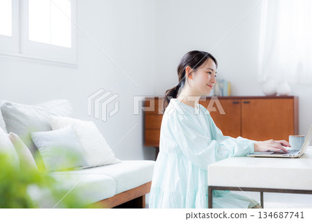 A woman using a computer in the living room A woman using a computer in the living room 134687741