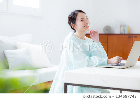 A woman using a computer in the living room 134687742