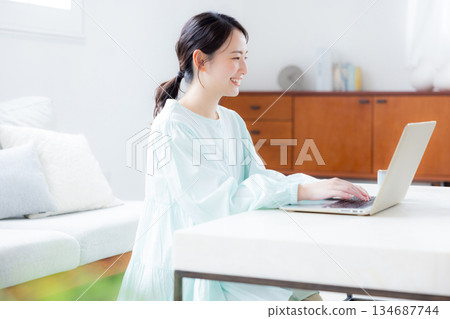 A woman using a computer in the living room 134687744