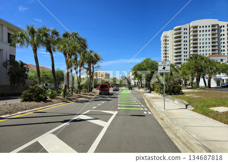 Public street in Sarasota, Florida features a green bike lane next to car traffic, part of city infrastructure for active and eco travel Public street in Sarasota, Florida features a green bike lane next to car traffic, part of city infrastructure for active and eco travel 134687818