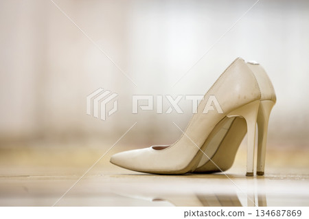 Pair of fashionable comfortable high heel leather beige female shoes isolated on light copy space background. Style and fashion, modern footwear concept. 134687869