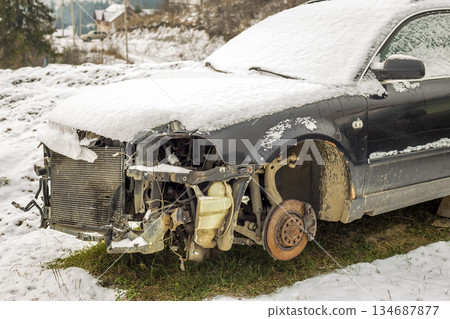Old forsaken abandoned rusty broken trash car covered with snow without wheels on winter day outdoors in field. Old forsaken abandoned rusty broken trash car covered with snow without wheels on winter day outdoors in field. 134687877