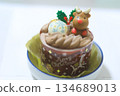 A cute Christmas chocolate cake decorated with holly leaves and reindeer 134689013