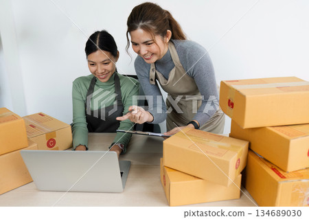 Asian woman using laptop to prepare for delivery to customer. e-business concept 134689030