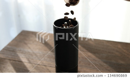 將咖啡豆放入咖啡研磨機 將咖啡豆放入咖啡研磨機 134690869