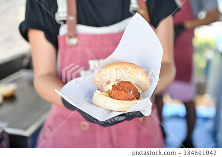 Image of a staff member carrying a homemade shark burger Image of a staff member carrying a homemade shark burger 134691042