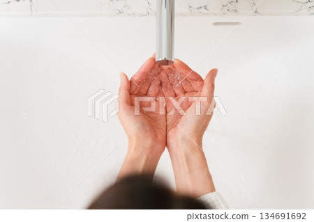 Woman washing her hands in the bathroom Lifestyle image Woman washing her hands in the bathroom Lifestyle image 134691692